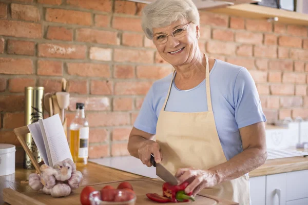 Mulher madura preparando comida saborosa — Fotografia de Stock