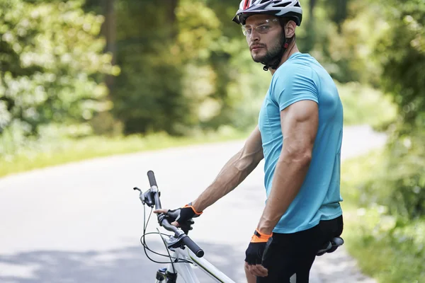 Giovane in bicicletta in cerca di fotocamera — Foto Stock