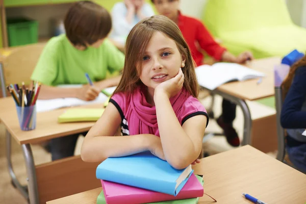 Female pupil sitting with books on the lesson. — Stock Photo, Image