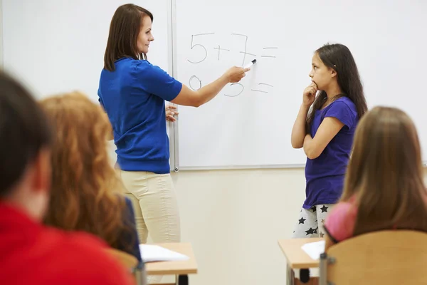 Profesor preguntando a estudiante al lado de la pizarra — Foto de Stock