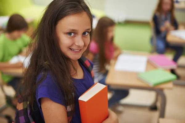 Female pupil standing with book Stock Photo