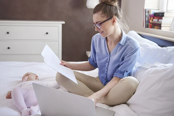 Madre trabajando mientras su hijo duerme — Foto de Stock