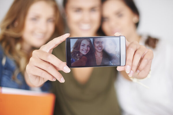 Best friends taking selfie on mobile phone