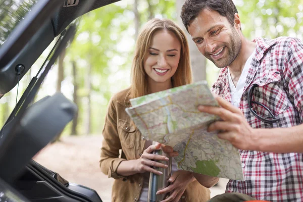 Pareja buscando su destino en el mapa — Foto de Stock