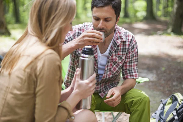 Pareja bebiendo té caliente en el camping —  Fotos de Stock