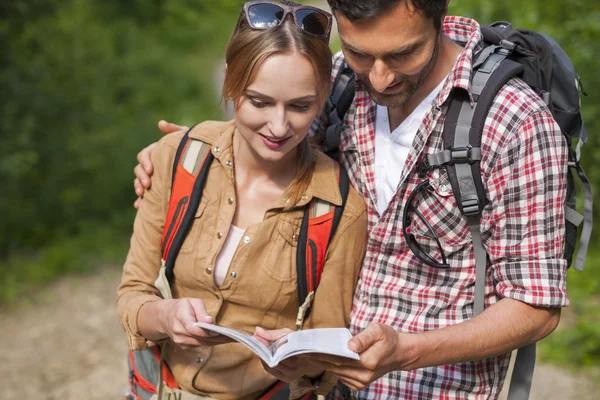 Pareja buscando información útil en la guía — Foto de Stock