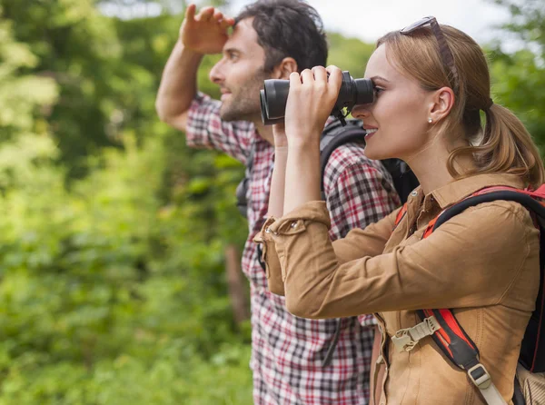 Woman looking through the binoculars — Stock Photo, Image