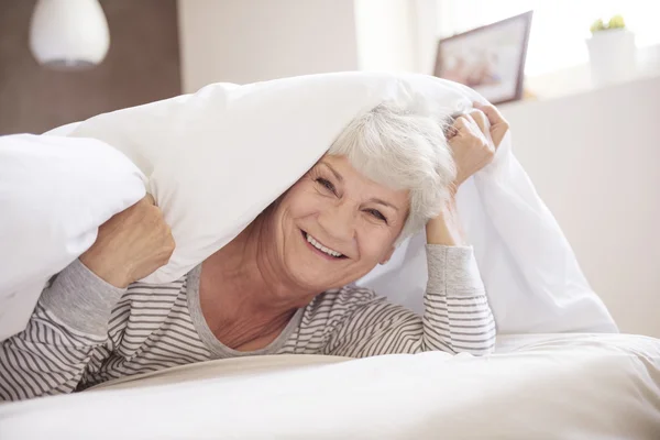 Reife Frau lächelt im Bett — Stockfoto