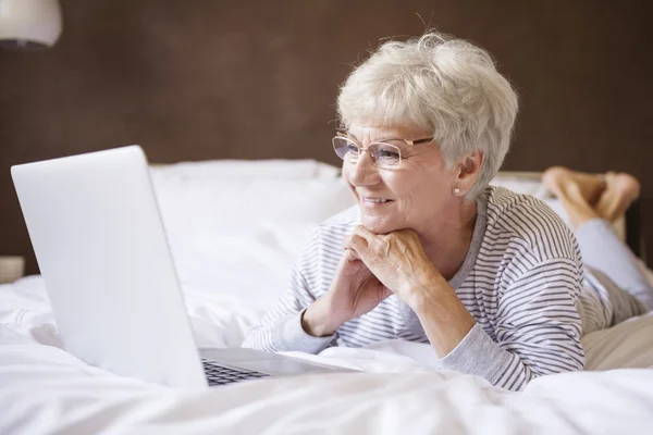 成熟的女人在床上笔记本电脑 — 图库照片
