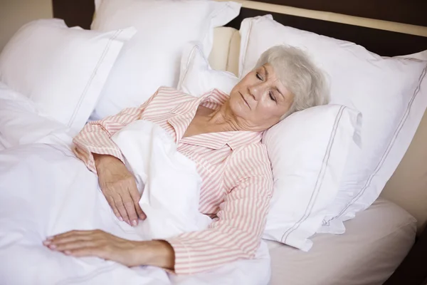 Mogen kvinna sova i sängen — Stockfoto