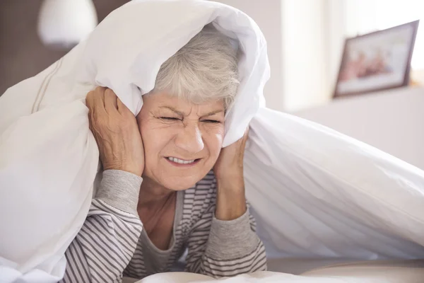 Mujer madura en la cama con dolor de cabeza — Foto de Stock