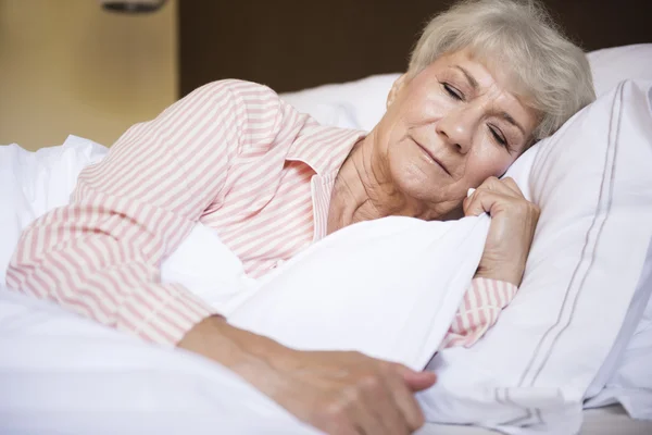 Mature woman sleeping in bed — Stock Photo, Image