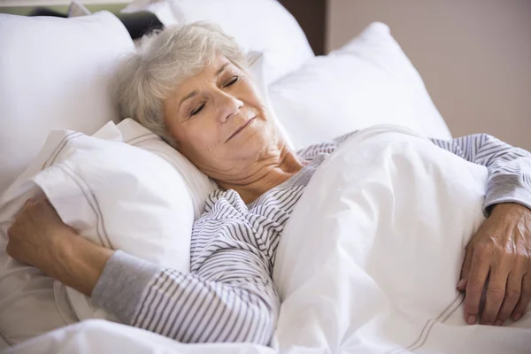 Reife Frau schlafen in Bett — Stockfoto