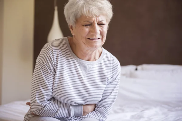 Зрелая женщина с болью в животе — стоковое фото