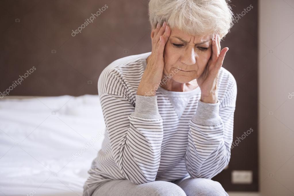 mature woman in bed with headache