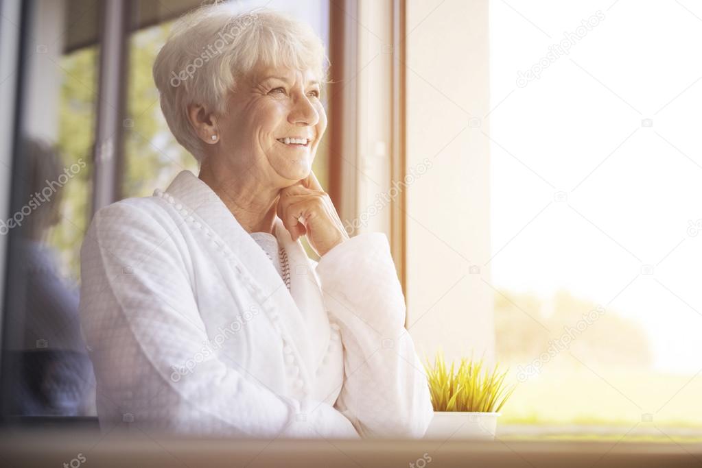 mature woman smiling  near window