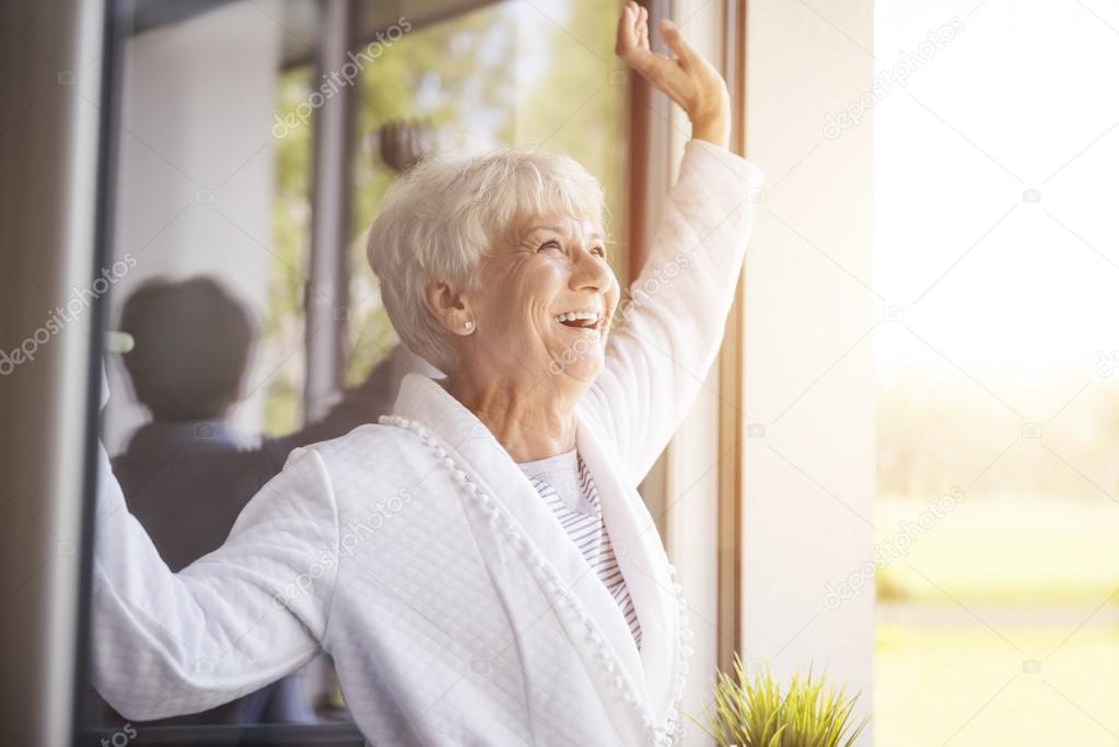 mature woman smiling  near window