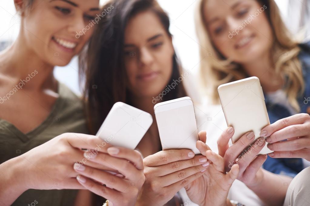 young female  students with smartphones