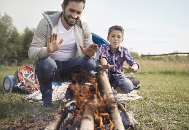 Baba ve oğul kamp ateşi yakın