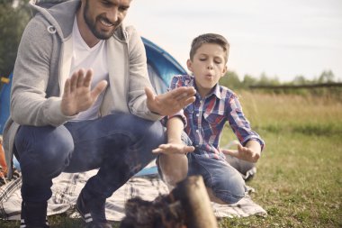Baba ve oğul kamp ateşi yakın