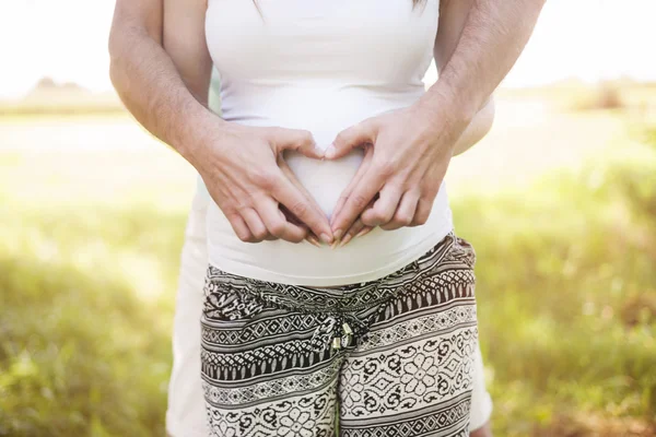 Pregnant belly with heart shaped gesture — Stock Photo, Image