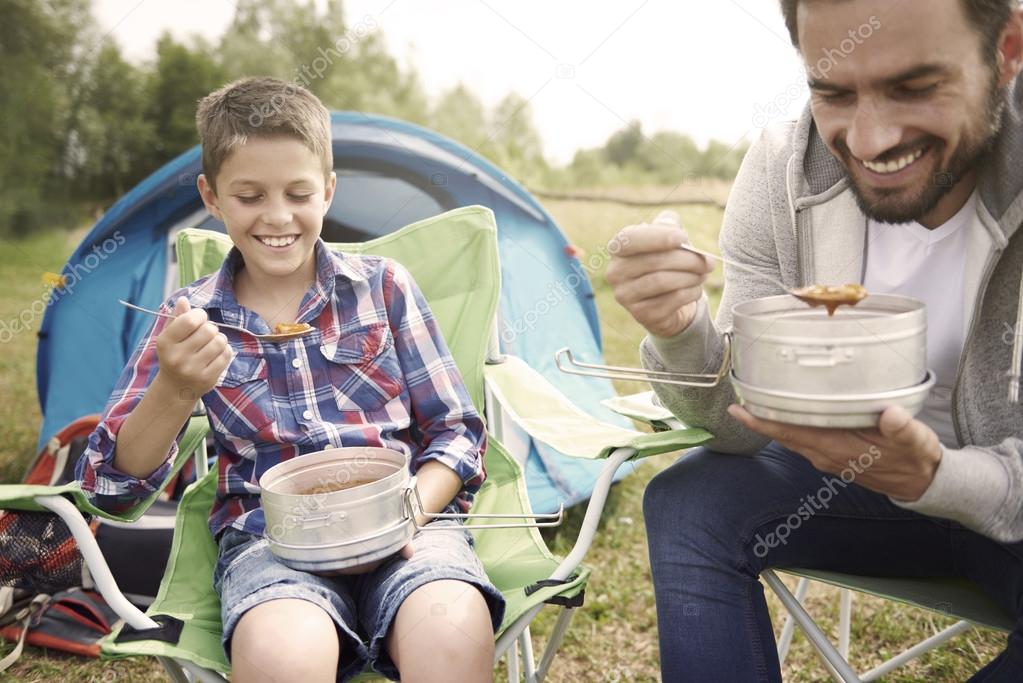father and son eating soup