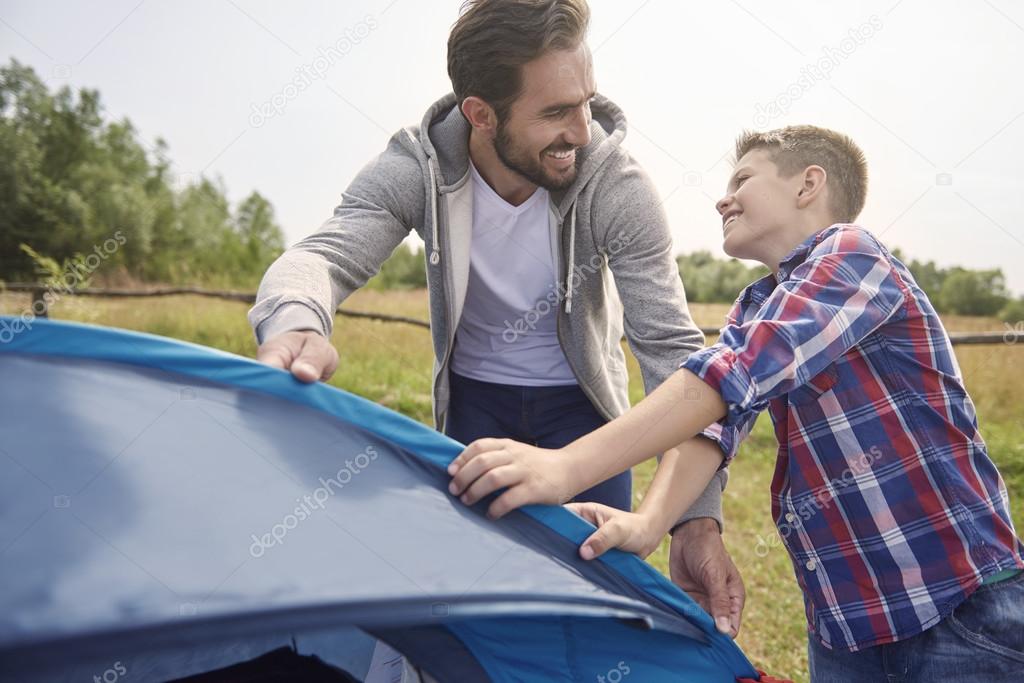 father and son pitching tent