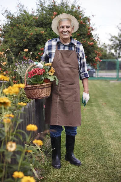 Starší muž s košíkem květin — Stock fotografie