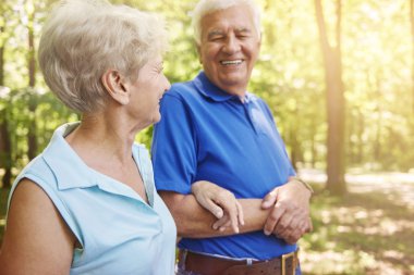 Yaşlı çift ormanda yürüyor.