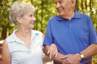 Yaşlı çift ormanda yürüyor.