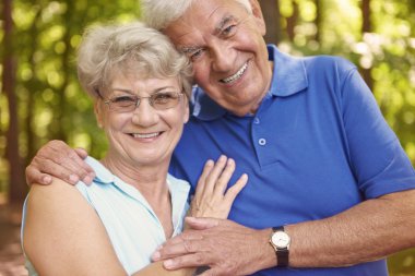 Yaşlı çift ormanda yürüyor.