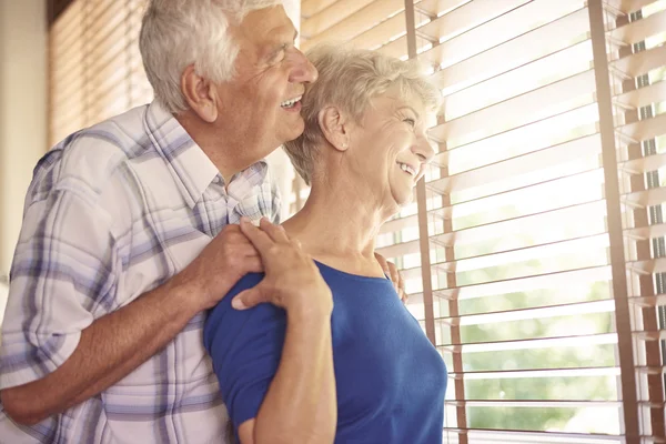 Senior paar op zoek door het raam — Stockfoto