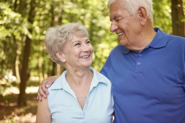 Yaşlı çift ormanda yürüyor.