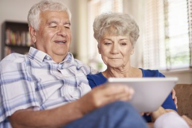 Dijital tablet kullanan yaşlı çift.