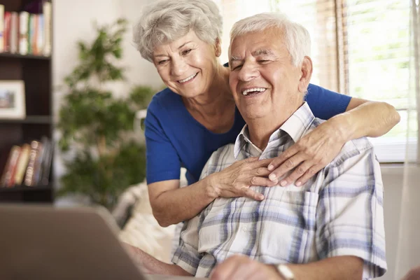 Счастливые бабушки и дедушки с ноутбуком — стоковое фото