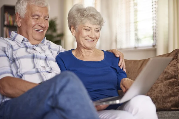 Feliz pareja de ancianos utilizando el ordenador portátil — Foto de Stock