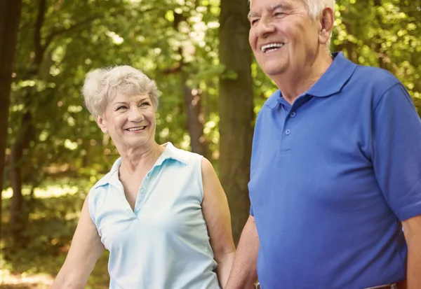 Lyckliga äldre par promenader i parken — Stockfoto