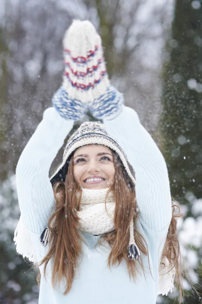 Flicka som försöker fånga några snöflingor — Stockfoto