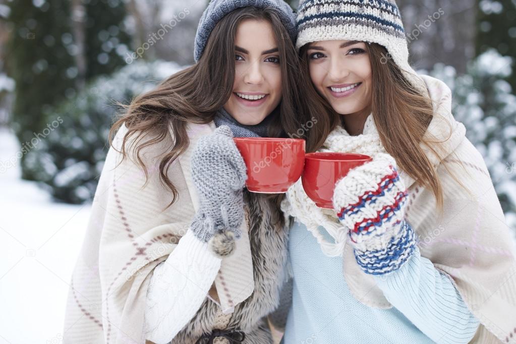 Happy girls drinking hot tea