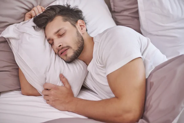 Homem exausto dormindo em sua cama — Fotografia de Stock