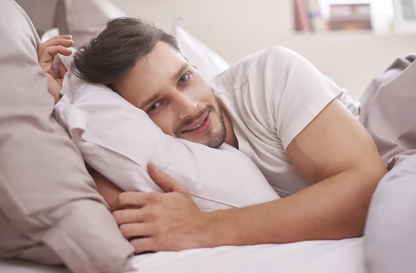 Dinlenmiş adam yatağında yatan — Stok fotoğraf