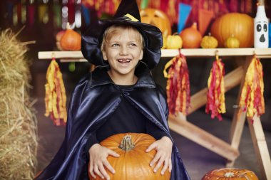 Cadılar Bayramı partisinde balkabağı tutan çocuk