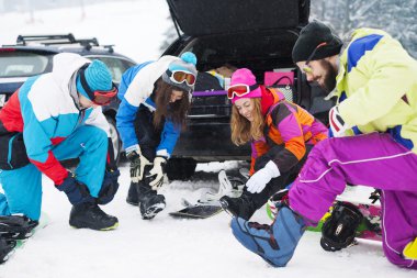 Arkadaşlar kayak pisti snowboard için hazırlanıyor