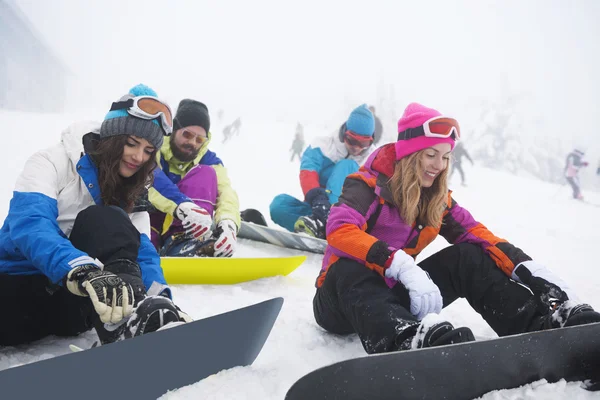 Φίλοι προετοιμασία για snowboarding σε πίστα σκι — Φωτογραφία Αρχείου