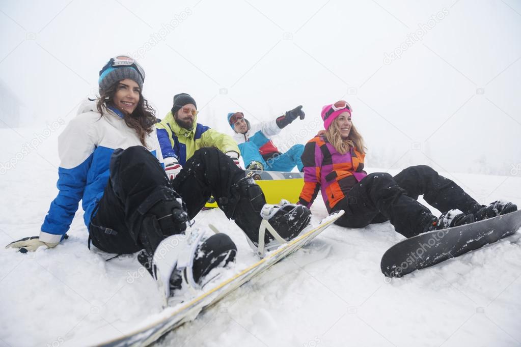 Friends preparing for snowboarding at ski slope