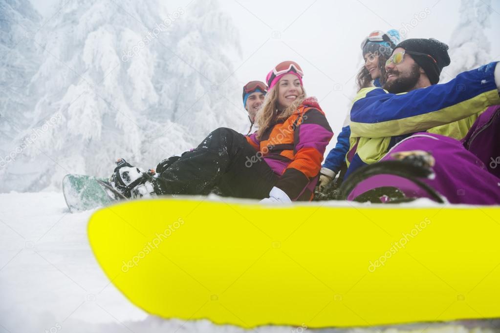 Friends preparing for snowboarding at ski slope