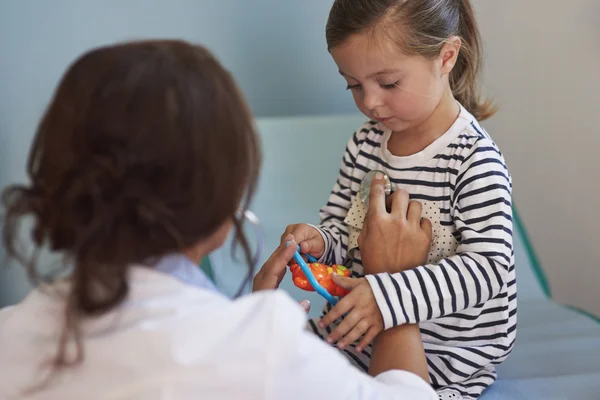 Arzt untersucht ihre kleine Patientin — Stockfoto