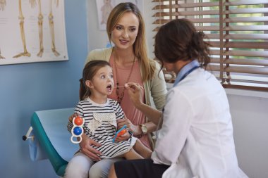 Mother and daughter visit a doctor clipart