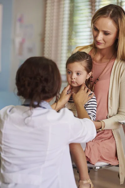 Médico revisando la garganta de la niña — Foto de Stock