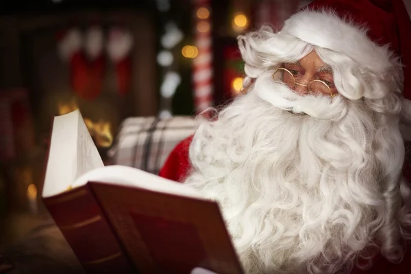 Weihnachtsmann liest Buch — Stockfoto